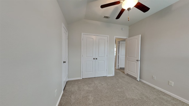 unfurnished bedroom featuring lofted ceiling, a closet, visible vents, carpet flooring, and baseboards