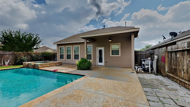 back of property with a patio area, a fenced backyard, ceiling fan, a fenced in pool, and an in ground hot tub