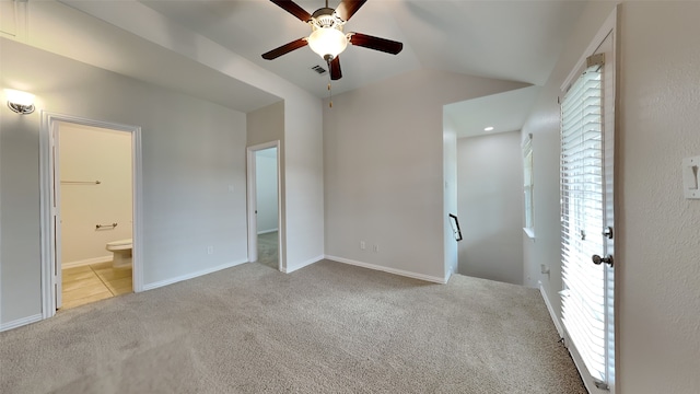 unfurnished bedroom featuring lofted ceiling, ensuite bathroom, visible vents, multiple windows, and carpet floors