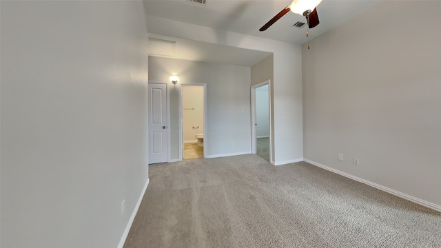 empty room featuring baseboards, light carpet, visible vents, and ceiling fan
