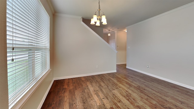unfurnished dining area with an inviting chandelier, wood finished floors, crown molding, baseboards, and stairs