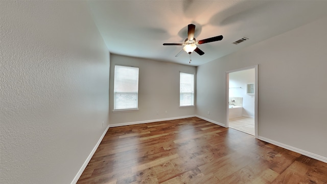 unfurnished bedroom with baseboards, a ceiling fan, visible vents, and wood finished floors