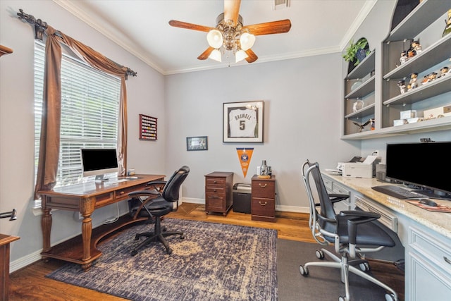 home office with a ceiling fan, wood finished floors, crown molding, and baseboards