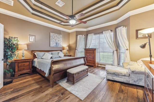 bedroom featuring a raised ceiling, hardwood / wood-style floors, ornamental molding, and ceiling fan