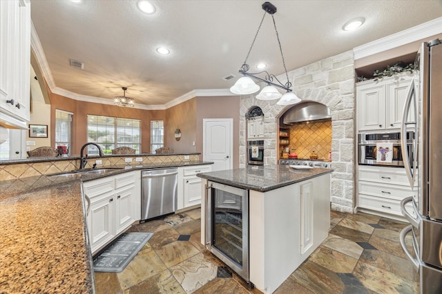 kitchen featuring stainless steel appliances, beverage cooler, a sink, backsplash, and white cabinetry