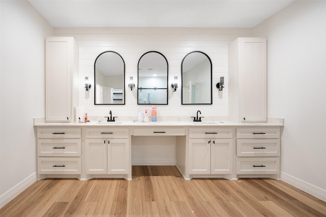 24585 Tipperary St, Hempstead, TX 77445 - bathroom with baseboards, a sink, and wood finished floors