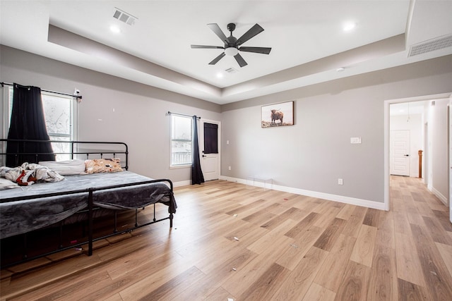 24585 Tipperary St, Hempstead, TX 77445 - bedroom with a tray ceiling, baseboards, light wood-type flooring, and visible vents