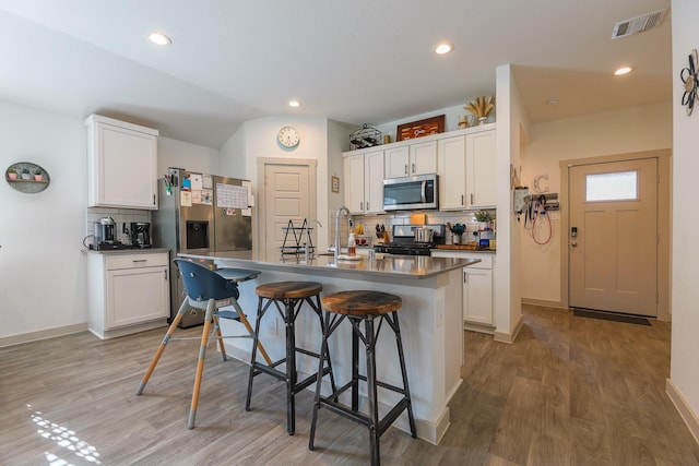 1830 William Scott St, Baytown, TX 77523 - kitchen featuring stainless steel appliances, tasteful backsplash, a kitchen breakfast bar, and visible vents