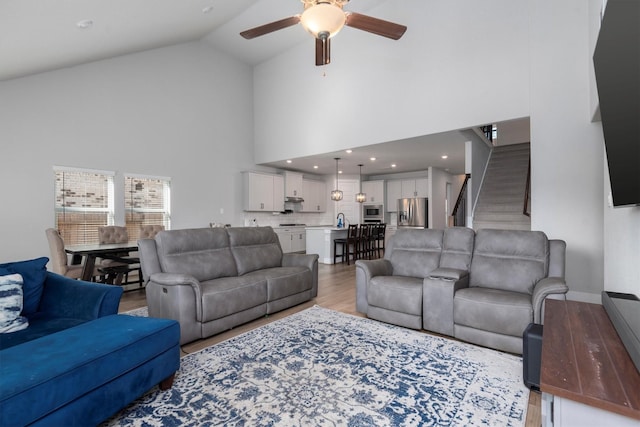 17828 Hanson Ridge Dr, Conroe, TX 77316 - living area with ceiling fan, stairway, light wood-style flooring, and high vaulted ceiling