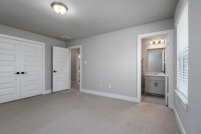 17828 Hanson Ridge Dr, Conroe, TX 77316 - unfurnished bedroom featuring carpet, baseboards, multiple windows, and ensuite bathroom