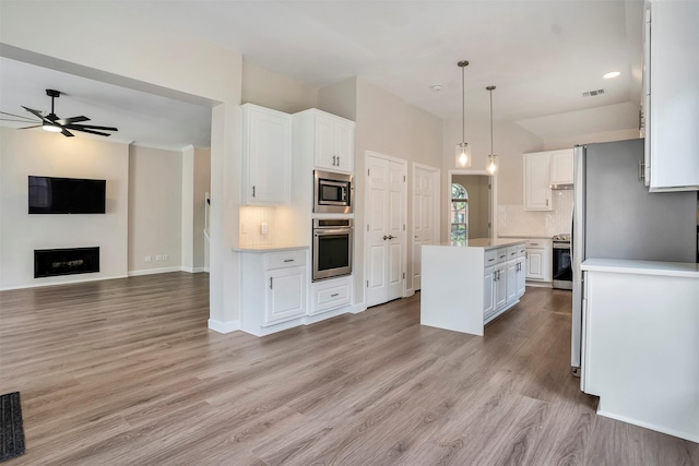 17422 Marigold Dr, Sugar Land, TX 77479 - kitchen featuring appliances with stainless steel finishes, decorative backsplash, white cabinetry, and light countertops