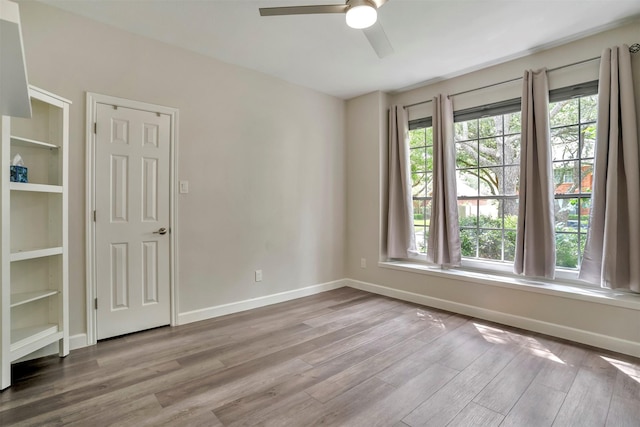 17422 Marigold Dr, Sugar Land, TX 77479 - empty room featuring wood finished floors, healthy amount of natural light, a ceiling fan, and baseboards