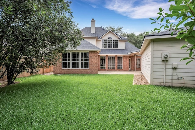 17422 Marigold Dr, Sugar Land, TX 77479 - back of property featuring a shingled roof, a lawn, a patio, brick siding, and a chimney