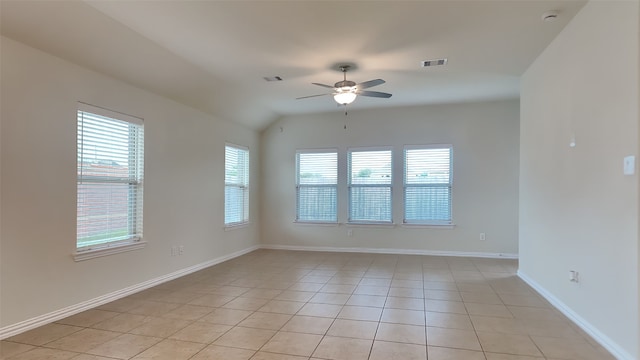 empty room featuring a healthy amount of sunlight, light tile patterned flooring, a ceiling fan, and visible vents