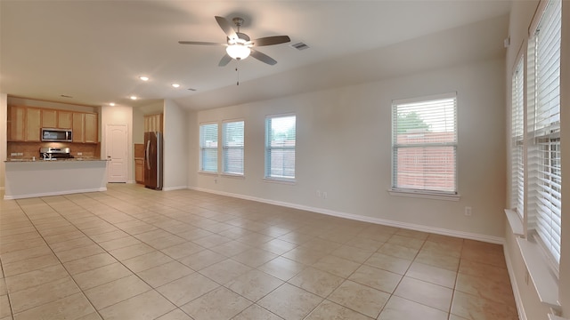 unfurnished living room with a wealth of natural light, light tile patterned floors, a ceiling fan, and recessed lighting