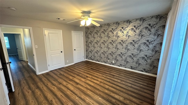 407 Bendwood Dr Unit 38, Houston, TX 77024 - unfurnished bedroom with wood finished floors, a ceiling fan, wallpapered walls, visible vents, and baseboards