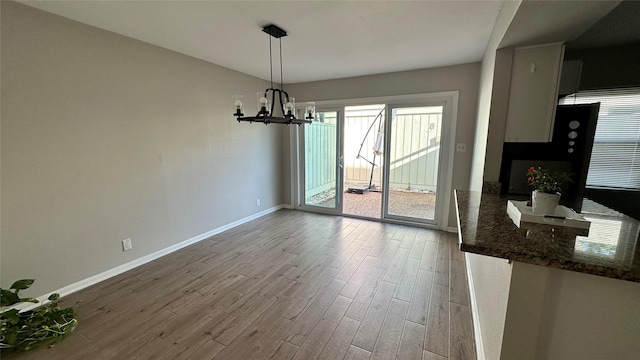 407 Bendwood Dr Unit 38, Houston, TX 77024 - unfurnished dining area with wood finished floors, baseboards, and a notable chandelier