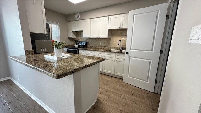 407 Bendwood Dr Unit 38, Houston, TX 77024 - kitchen with light wood-style floors, stainless steel electric range oven, refrigerator, and a sink