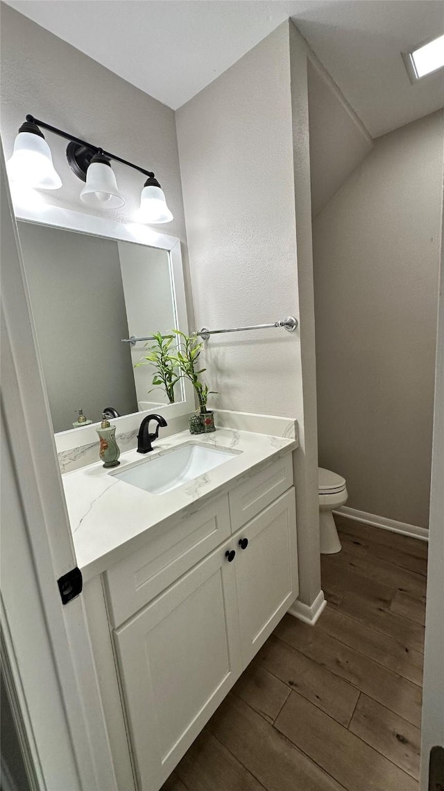 407 Bendwood Dr Unit 38, Houston, TX 77024 - bathroom featuring vanity, toilet, baseboards, and wood finished floors