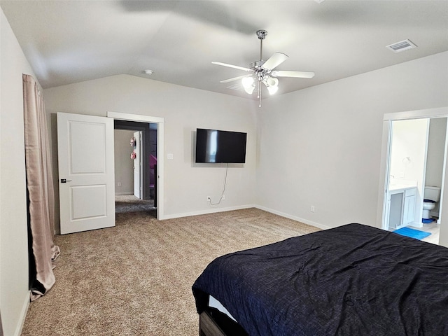 carpeted bedroom featuring lofted ceiling, ensuite bathroom, visible vents, a ceiling fan, and baseboards