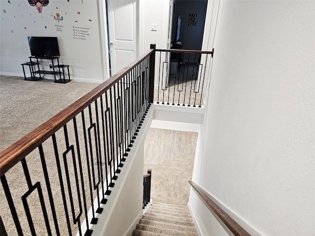 stairway featuring carpet floors and baseboards