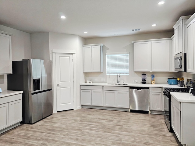 kitchen featuring a sink, stainless steel appliances, visible vents, light countertops, and recessed lighting