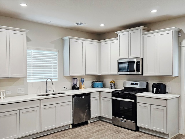 kitchen with recessed lighting, stainless steel appliances, visible vents, a sink, and light countertops