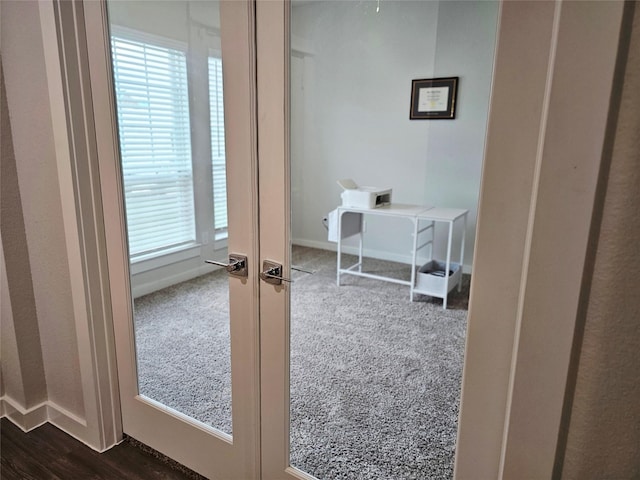 interior space featuring baseboards and dark carpet
