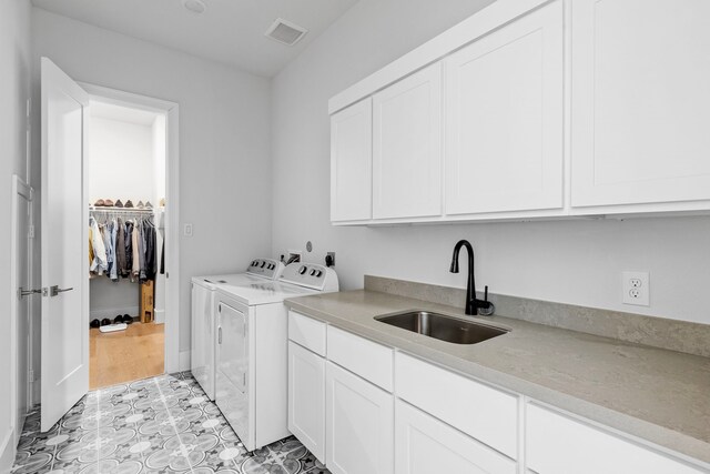 203 S Empress Green Pl, Montgomery, TX 77316 - laundry area featuring washer and dryer, cabinet space, visible vents, and a sink