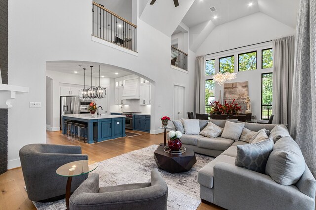 203 S Empress Green Pl, Montgomery, TX 77316 - living room with light wood finished floors, visible vents, a towering ceiling, and arched walkways