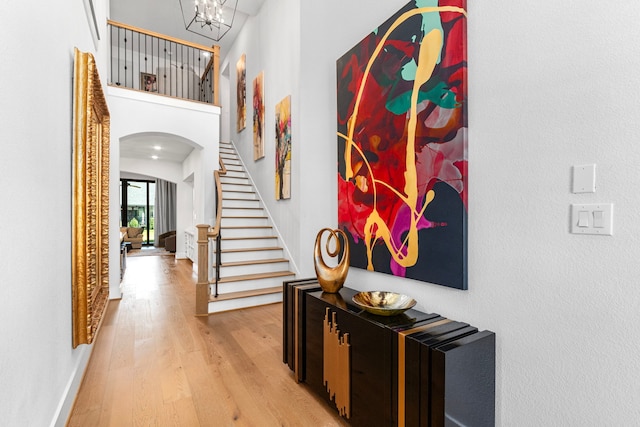 203 S Empress Green Pl, Montgomery, TX 77316 - hallway featuring baseboards, light wood finished floors, a towering ceiling, arched walkways, and stairway