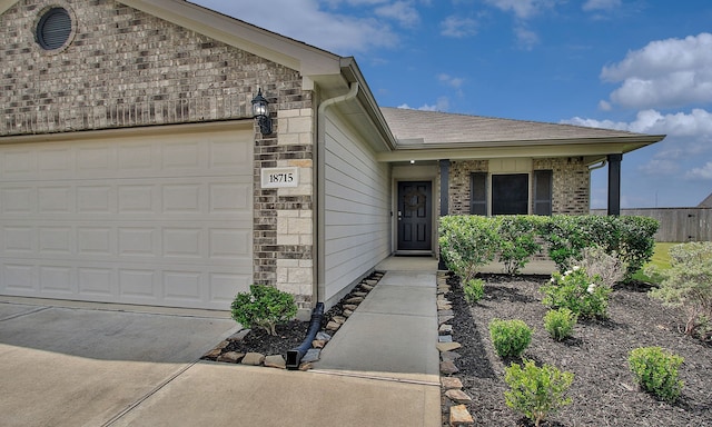 18715 Callalily Bloom Ct, Tomball, TX 77377 - view of front of home featuring a shingled roof, concrete driveway, brick siding, and a garage