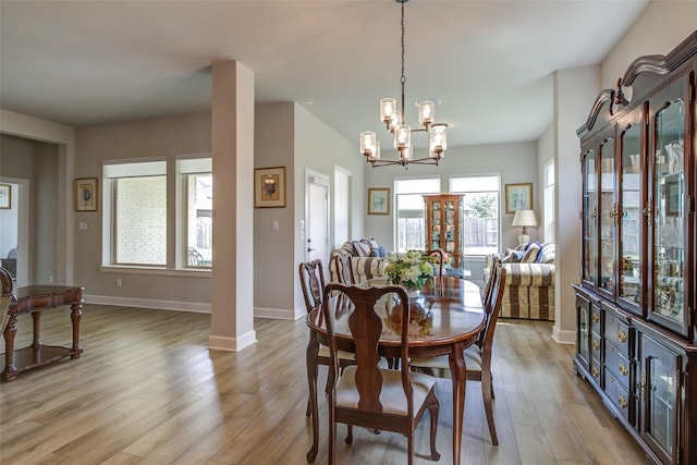 9823 Starry Night Ln, Manvel, TX 77578 - dining space featuring a notable chandelier, light wood-type flooring, and baseboards