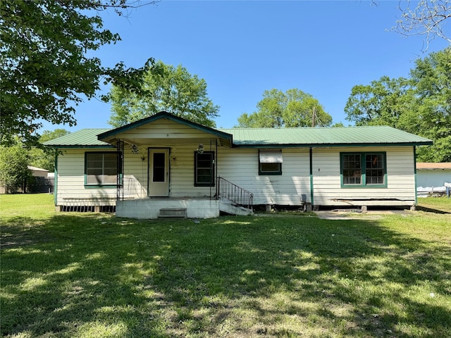 view of front of house featuring covered porch, metal roof, and a front lawn