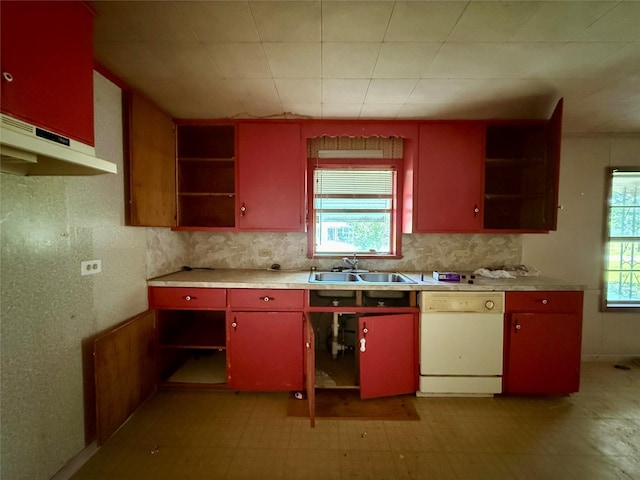 kitchen with under cabinet range hood, dishwasher, a sink, open shelves, and red cabinetry