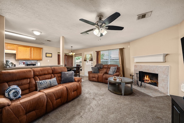 7210 Avocet Ln, Houston, TX 77040 - living area with a tiled fireplace, visible vents, ceiling fan with notable chandelier, and carpet floors