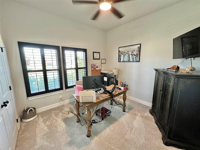 carpeted office space with lofted ceiling, baseboards, and a ceiling fan