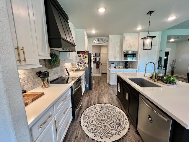 kitchen featuring a sink, stainless steel appliances, dark wood finished floors, light countertops, and custom exhaust hood