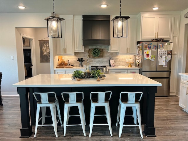 kitchen featuring freestanding refrigerator, tasteful backsplash, dark wood-type flooring, and custom range hood