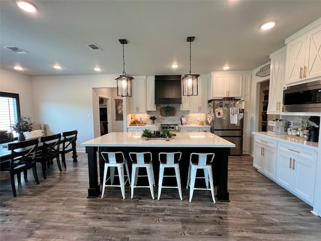 kitchen with stainless steel appliances, visible vents, white cabinetry, decorative backsplash, and light countertops