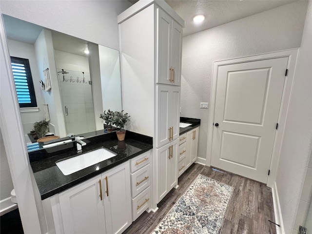 bathroom featuring a stall shower, vanity, and wood finished floors