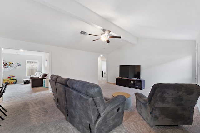 carpeted living area with arched walkways, ceiling fan, visible vents, and vaulted ceiling with beams