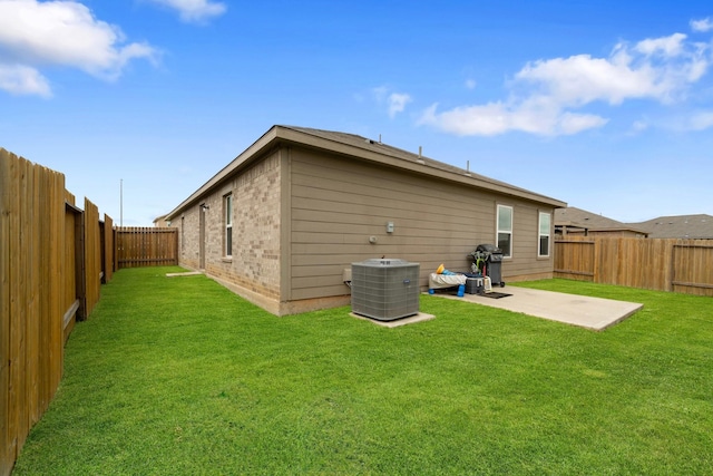 rear view of property featuring a fenced backyard, a patio, cooling unit, and a yard