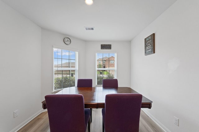 dining area with baseboards, light wood-style flooring, and visible vents