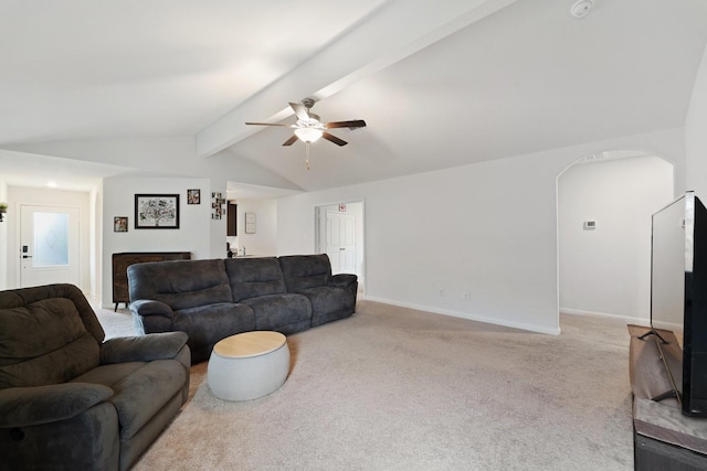 living room with carpet, a ceiling fan, lofted ceiling with beams, baseboards, and arched walkways