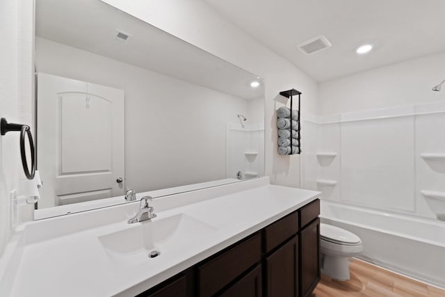 full bath featuring shower / bath combination, toilet, visible vents, vanity, and wood finished floors