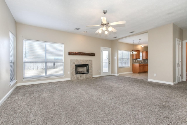 24006 Lestergate Dr, Spring, TX 77373 - unfurnished living room featuring a tiled fireplace, a wealth of natural light, and visible vents