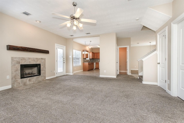 24006 Lestergate Dr, Spring, TX 77373 - unfurnished living room with stairs, light colored carpet, visible vents, a fireplace, and a ceiling fan