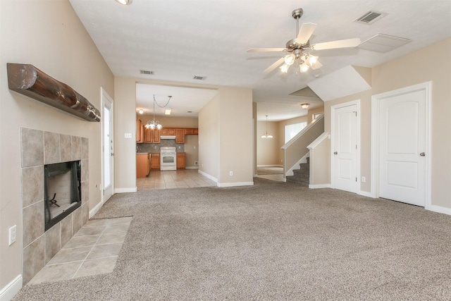 24006 Lestergate Dr, Spring, TX 77373 - unfurnished living room with stairway, light colored carpet, visible vents, and a tile fireplace
