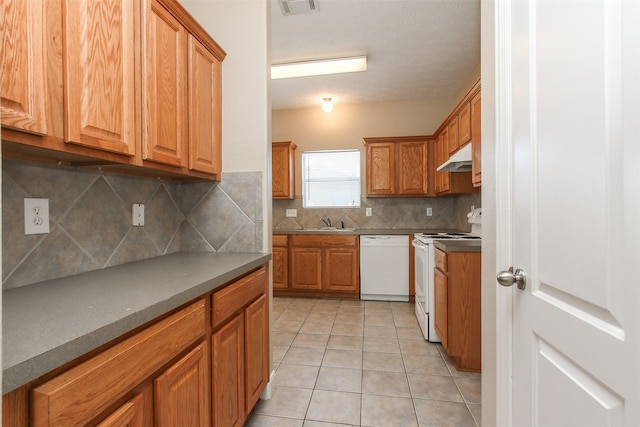 24006 Lestergate Dr, Spring, TX 77373 - kitchen featuring light tile patterned floors, a sink, white appliances, under cabinet range hood, and decorative backsplash